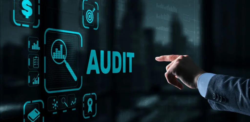 Male hand pointing on the word Audit on a screen